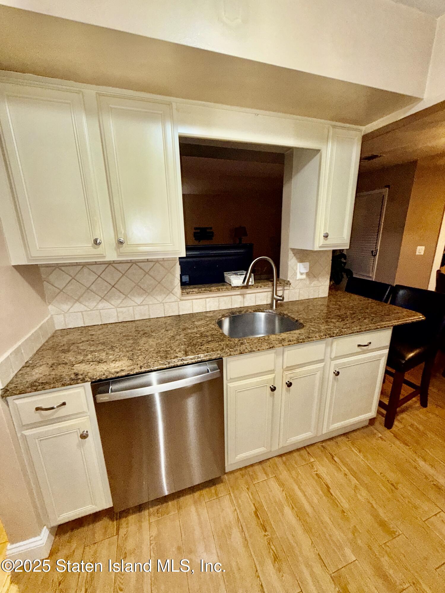 1446 Forest Hill Road, Unit 4 Staten Island, NY 10314 - Photo 7 of 24 a kitchen with granite countertop a sink stove and cabinets