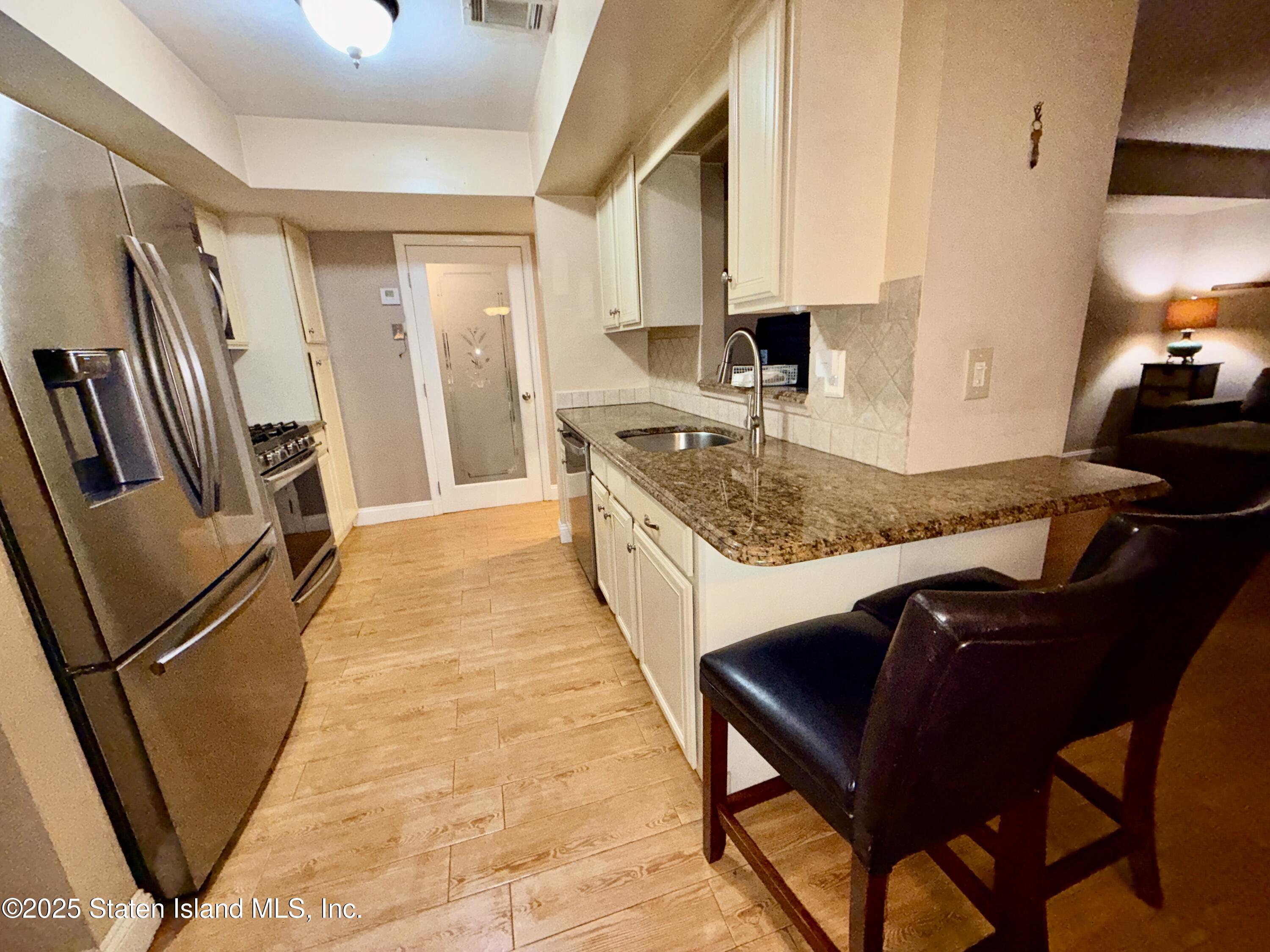 1446 Forest Hill Road, Unit 4 Staten Island, NY 10314 - Photo 8 of 24 a kitchen with sink cabinets and wooden floor