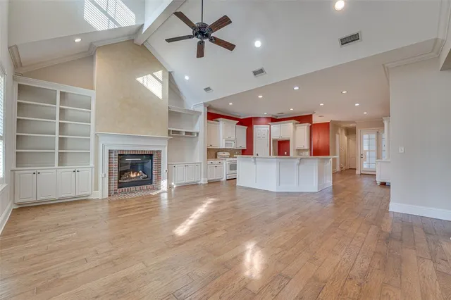 an open kitchen view with fireplace and wooden floor
