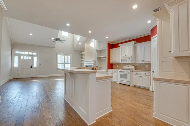 a kitchen with white cabinets sink and stove