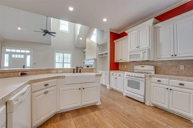 a large kitchen with granite countertop a sink stainless steel appliances and cabinets