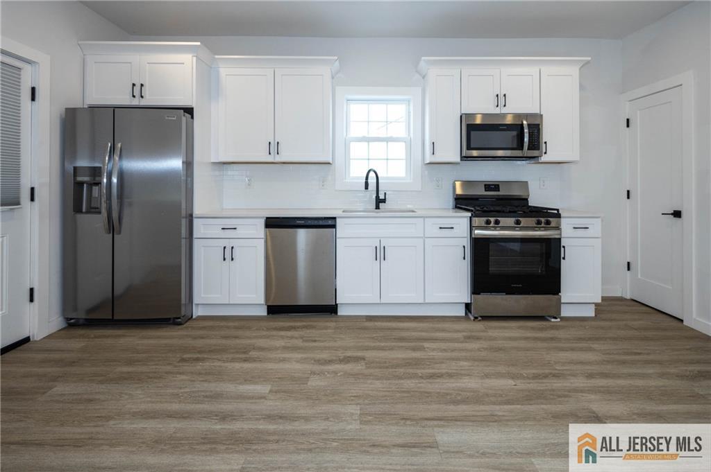 27 South 2nd Street Fords, NJ 08863 - Photo 8 of 32 a kitchen with stainless steel appliances granite countertop a stove a sink and a refrigerator