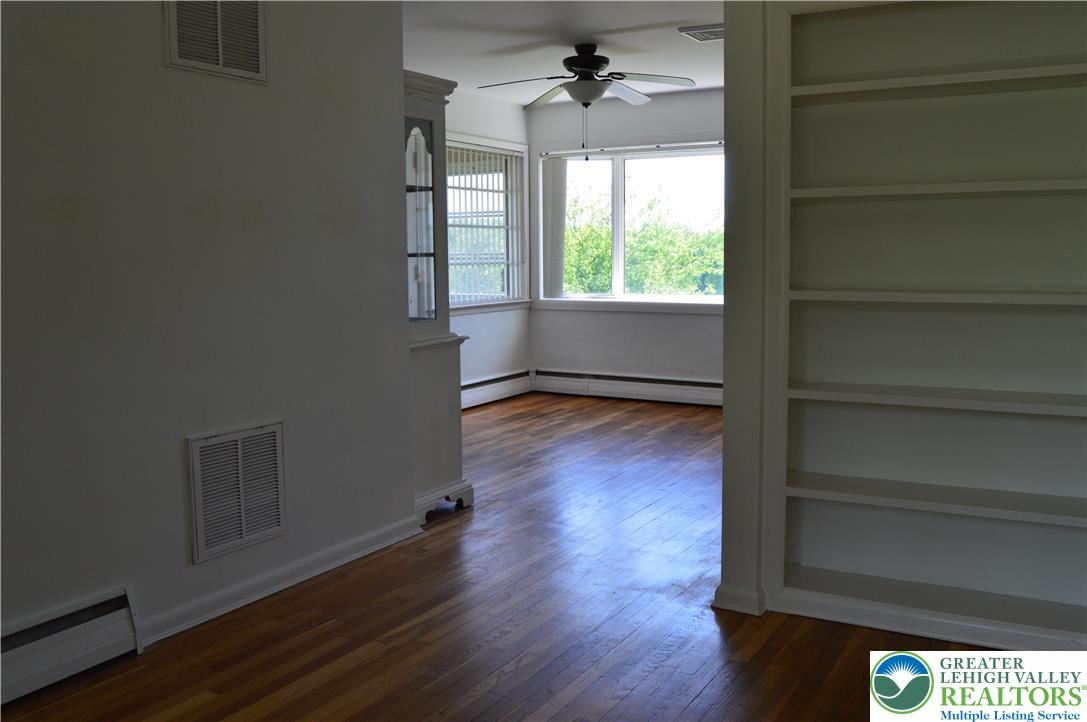 1819 Blue Barn Road Orefield, PA 18069 - Photo 13 of 21 Refined hardwood flooring graces this well-lit living area, featuring an integrated bookcase and scenic window views.