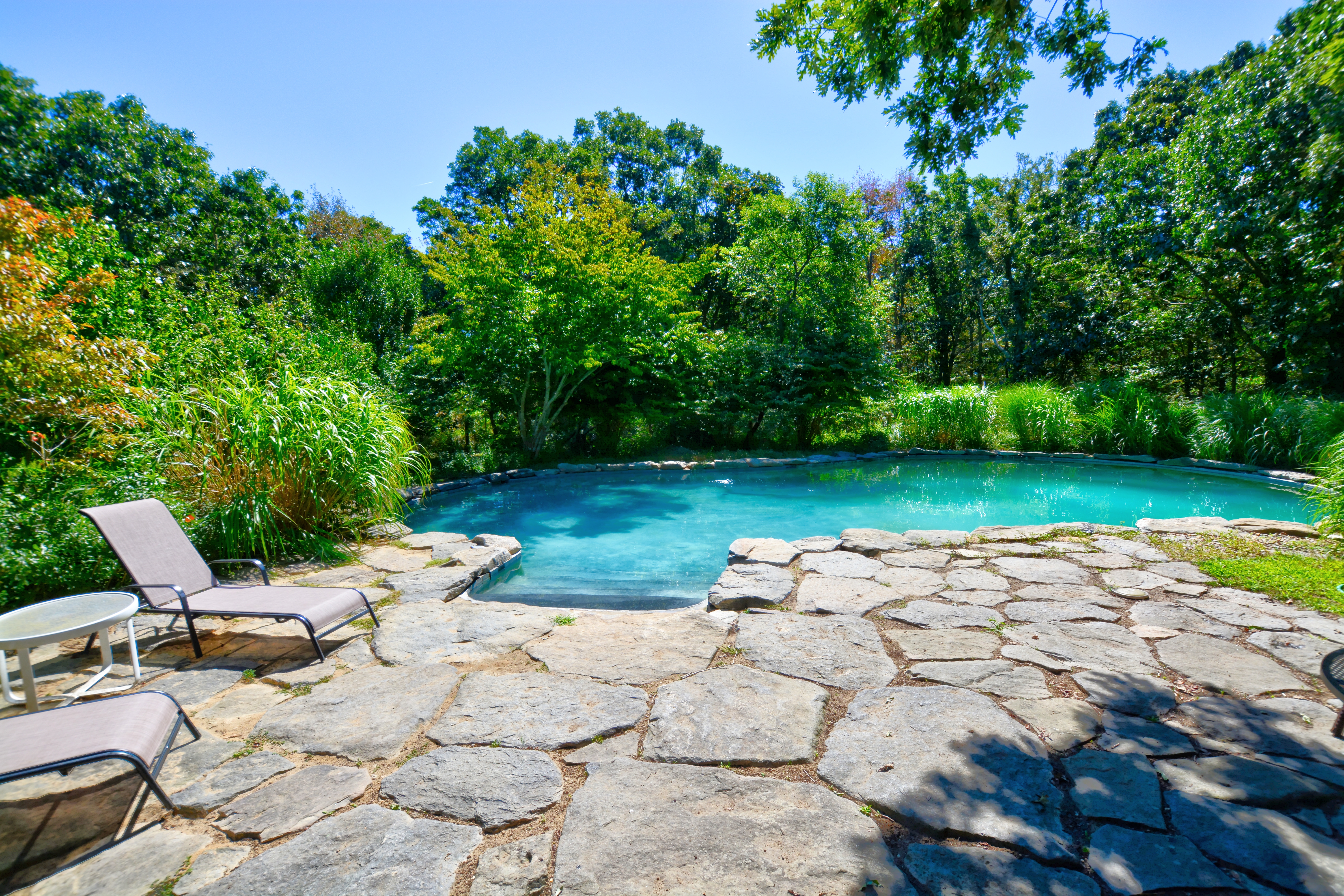 13 Kapigan Road Chilmark, MA 02535 - Photo 10 of 25 a view of a patio with a table and chairs under an umbrella