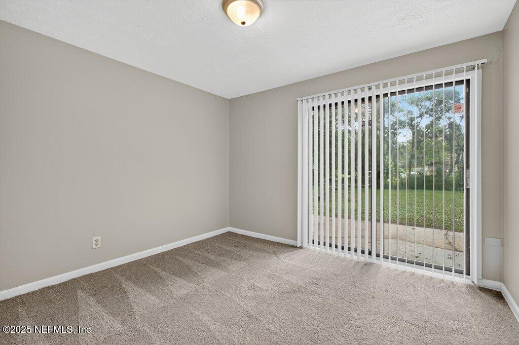7326 Melvin Road Jacksonville, FL 32210 - Photo 19 of 42 a view of an empty room with wooden floor and windows