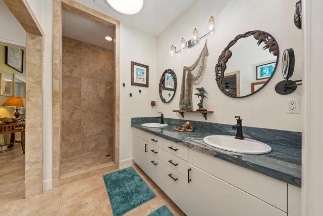 a bathroom with a granite countertop sink a mirror and a shower
