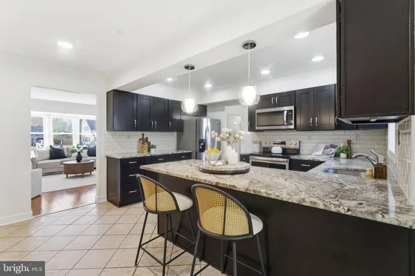 a kitchen with stainless steel appliances granite countertop a sink and a refrigerator