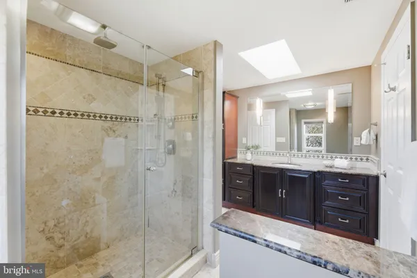 a bathroom with a granite countertop sink mirror and toilet