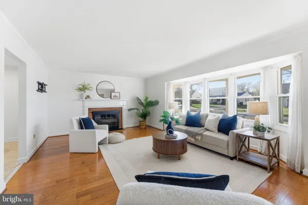 a living room with furniture a chandelier and kitchen view