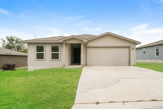 a front view of a house with a garden and yard