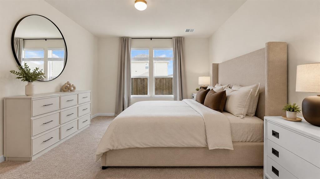 707 Indigo Road Princeton, TX 75407 - Photo 17 of 29 Spacious bedroom featuring light-colored walls, carpet flooring, a ceiling-mounted light fixture, and large windows with blinds and curtains