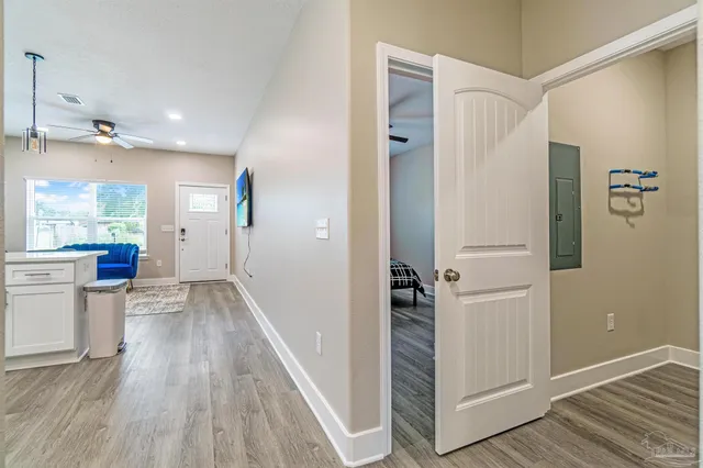 a view of a hallway with wooden floor and staircase