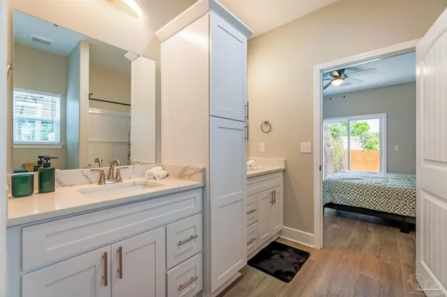 a en suite bathroom with a double vanity sink a mirror and a bathtub