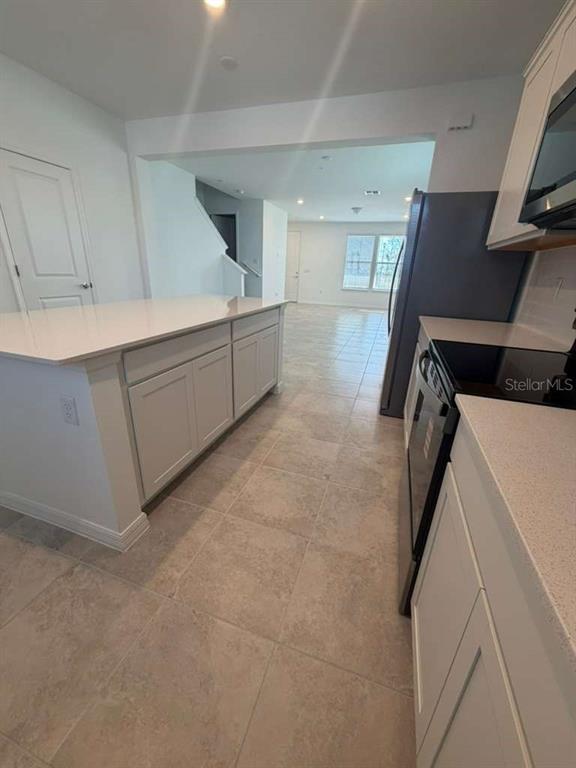 4617 Orchard View Alley Winter Garden, FL 34787 - Photo 7 of 32 a view of a kitchen with cabinets and wooden floor