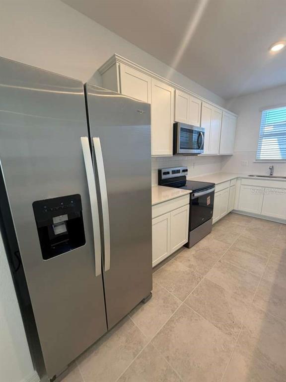4617 Orchard View Alley Winter Garden, FL 34787 - Photo 8 of 32 a kitchen with stainless steel appliances a refrigerator sink and microwave