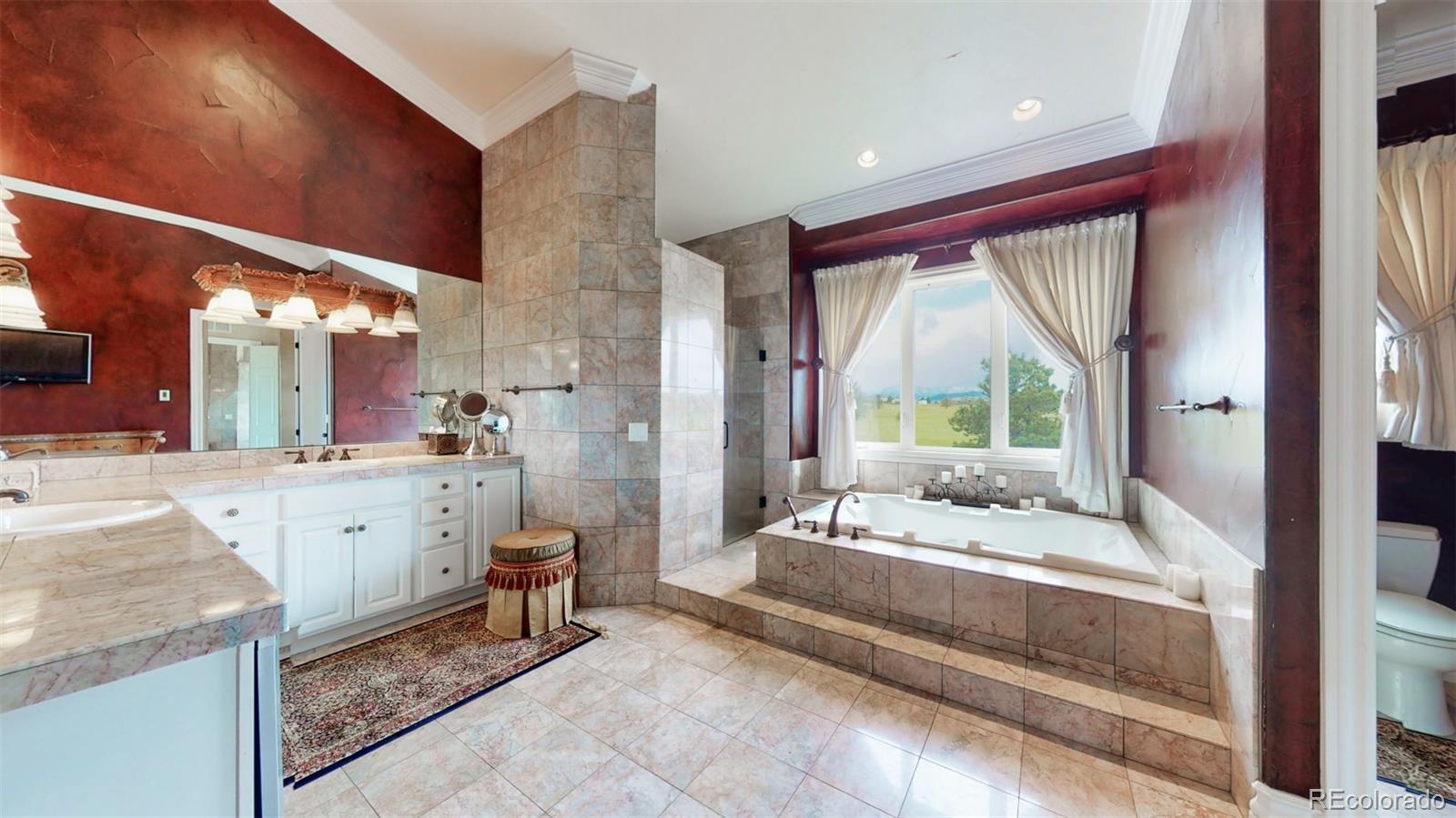 2775 E Highway Monument, CO 80132 - Photo 14 of 40 a large white bathroom with a large mirror vanity and shower