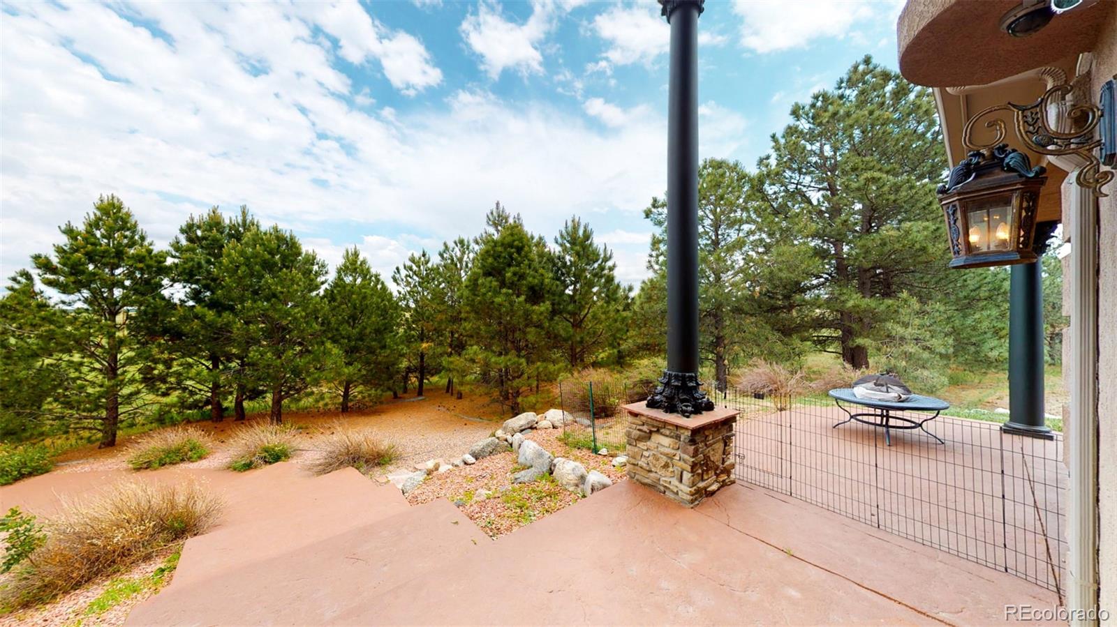 2775 E Highway Monument, CO 80132 - Photo 30 of 40 a backyard of a house with table and chairs