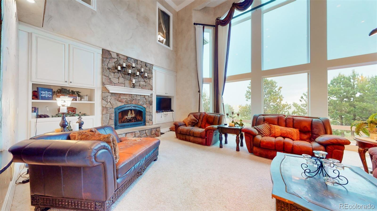 2775 E Highway Monument, CO 80132 - Photo 5 of 40 a living room with furniture a fireplace and floor to ceiling windows