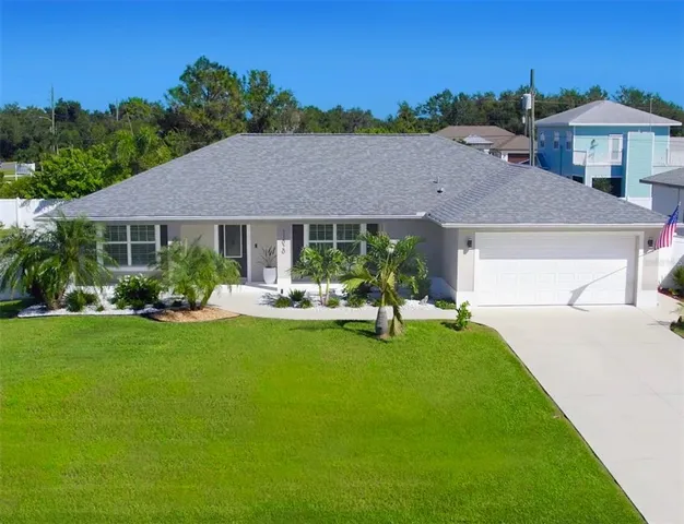 a aerial view of a house with table and chairs under an umbrella