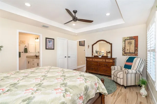 a bedroom with a bed large window and dresser