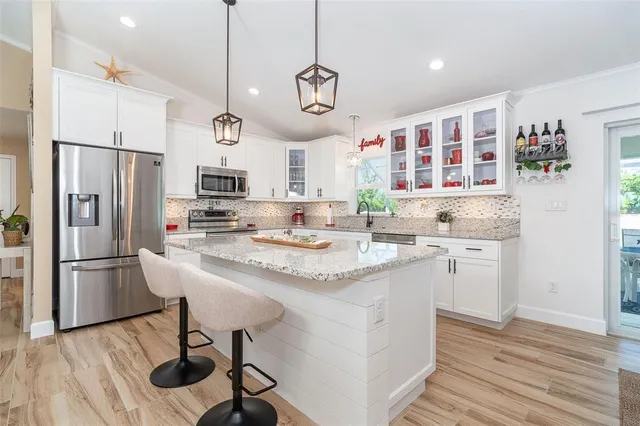 a kitchen with a refrigerator a sink and dishwasher with wooden floor