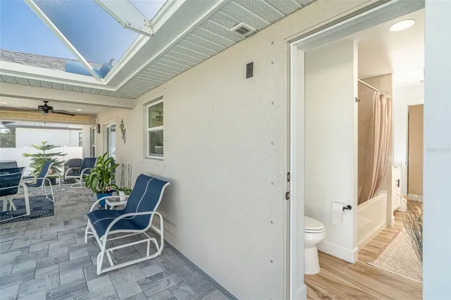 a view of a hallway with chairs and potted plant on a table