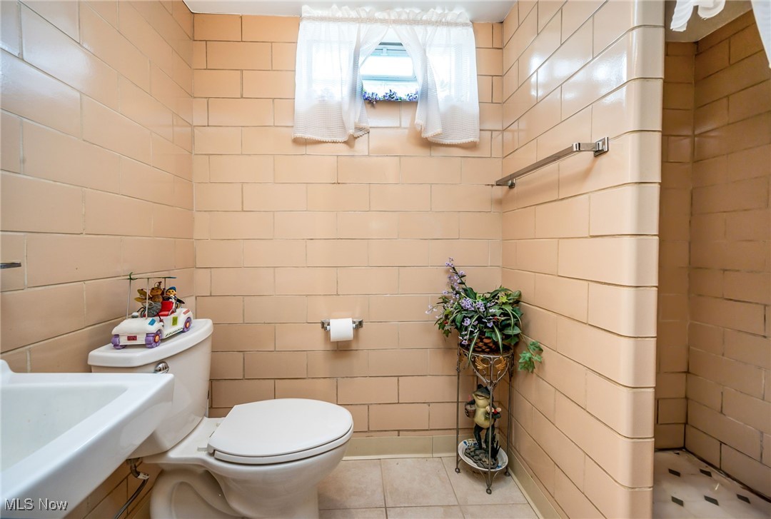 126 South Rhodes Avenue Niles, OH 44446 - Photo 22 of 23 Bathroom featuring tile floors, sink, toilet, and tile walls