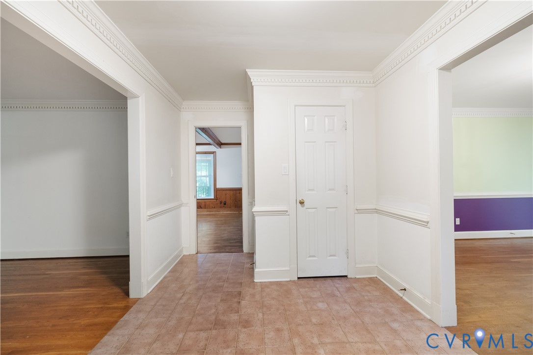 Corridor featuring crown molding, light wood finis