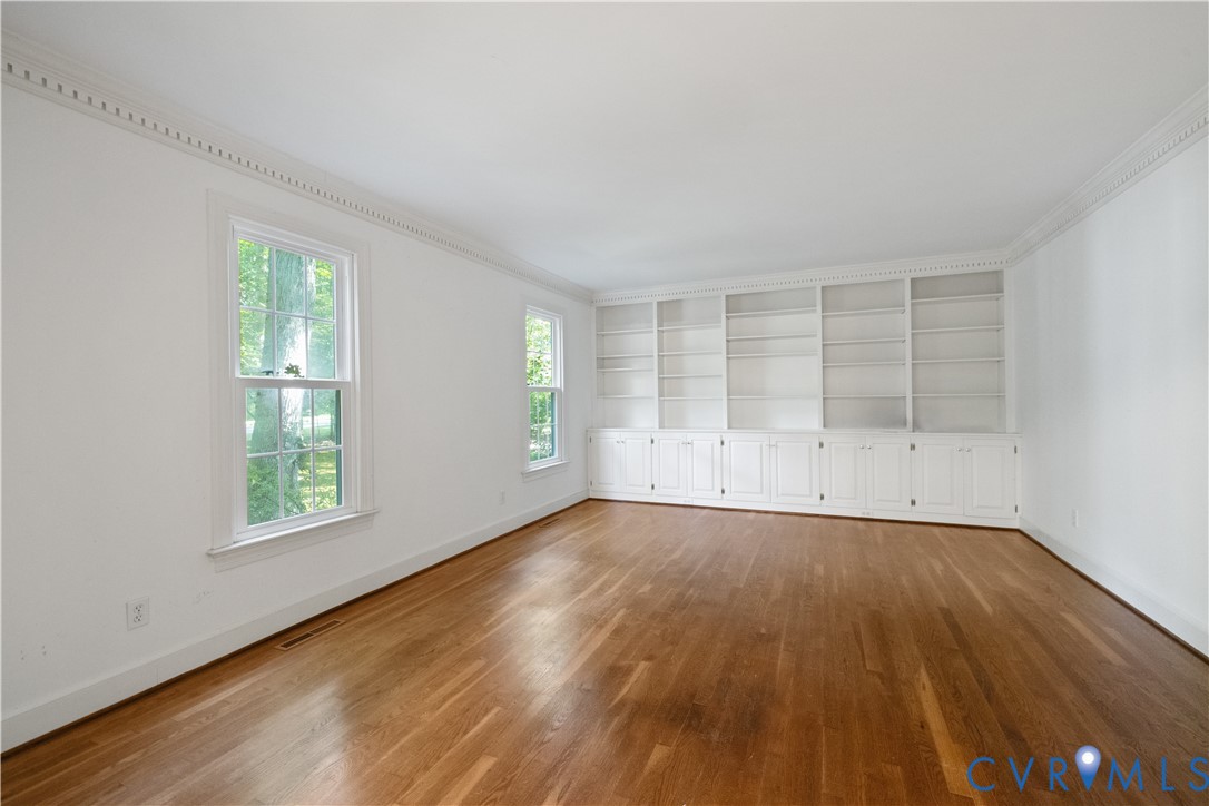 Unfurnished room featuring crown molding, wood fin