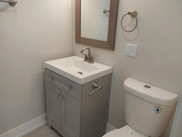 a bathroom with a sink a toilet and a mirror