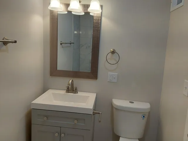 a bathroom with a toilet sink and mirror
