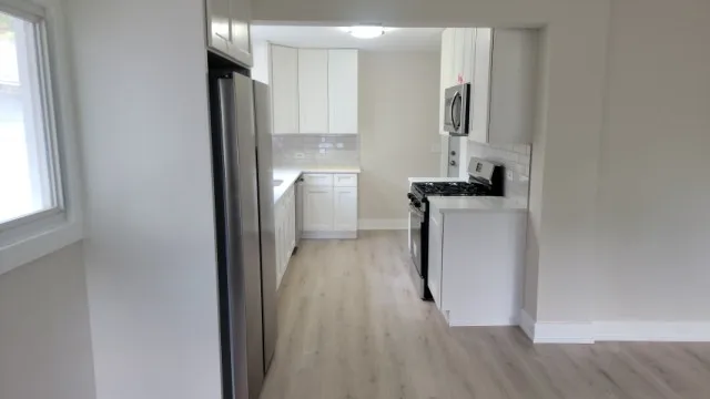 a kitchen with stainless steel appliances granite countertop a refrigerator and a sink