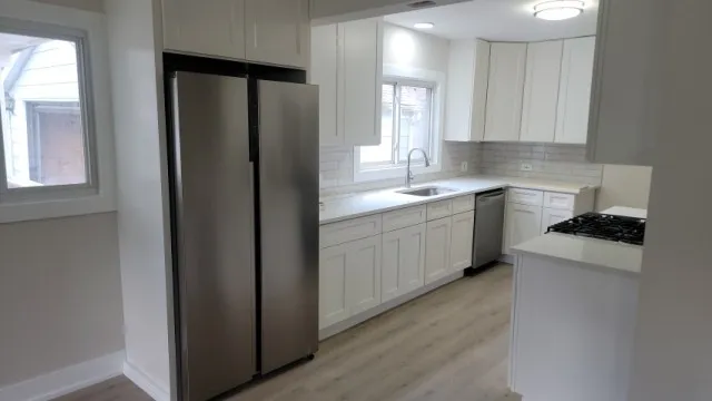 a kitchen with a sink a stove a refrigerator and cabinets