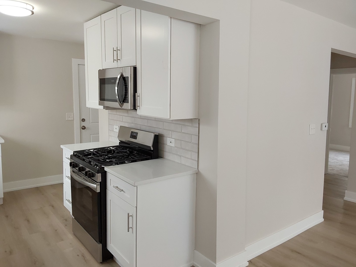 722 East Indiana Street Wheaton, IL 60187 - Photo 8 of 16 a kitchen with white cabinets and stainless steel appliances