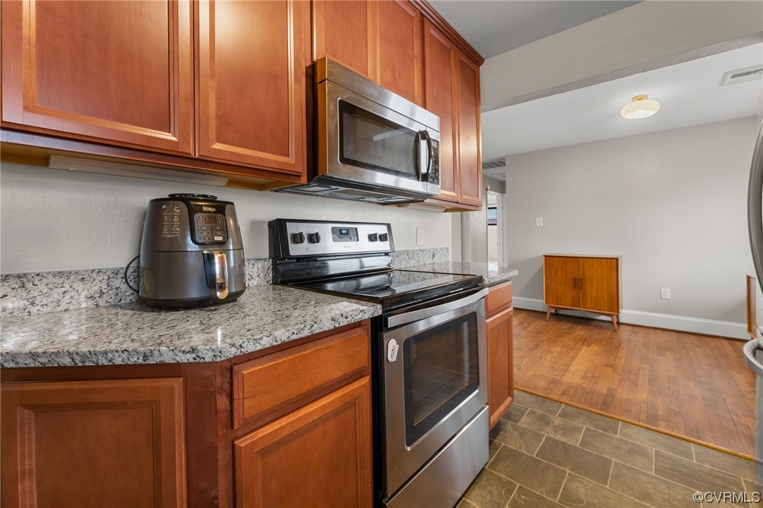 1221 Woodcroft Road Richmond, VA 23235 - Photo 13 of 42 a kitchen with stainless steel appliances granite countertop a stove a microwave and a sink