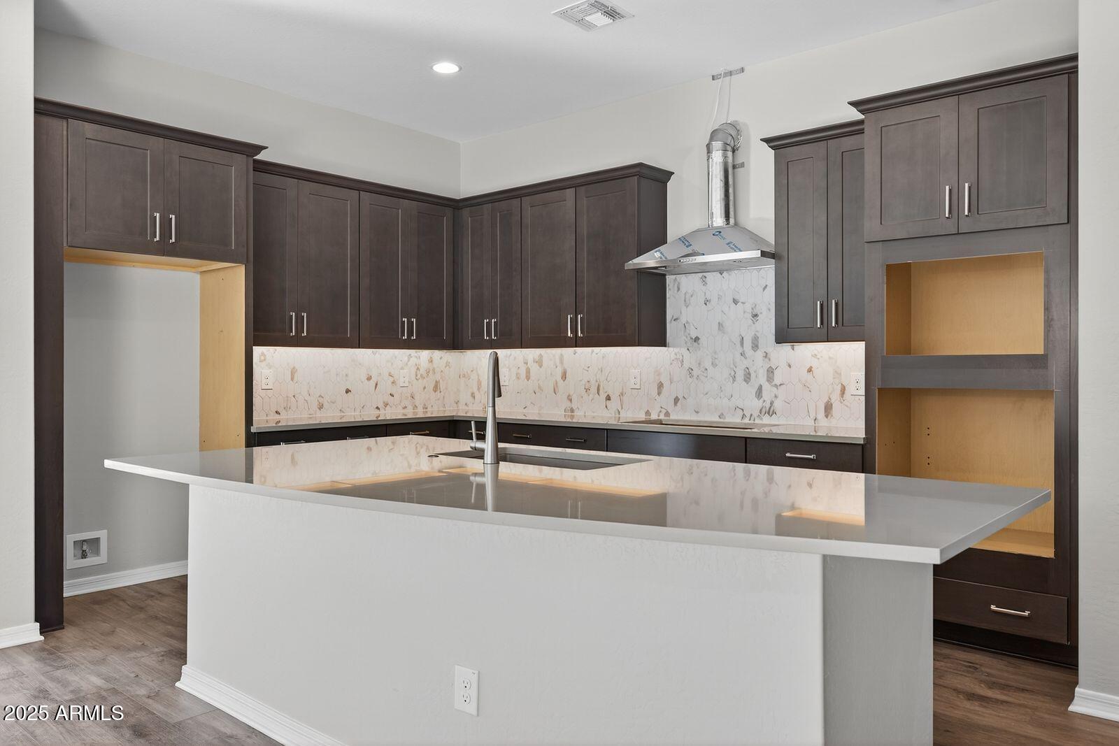 3191 West Santa Rosa Road San Tan Valley, AZ 85144 - Photo 11 of 52 a kitchen with kitchen island a stove a refrigerator and wooden cabinets with wooden floor