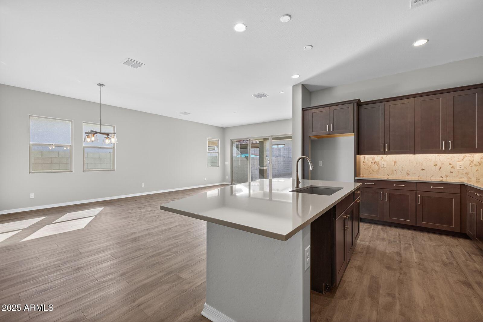 3191 West Santa Rosa Road San Tan Valley, AZ 85144 - Photo 13 of 52 a kitchen with stainless steel appliances granite countertop a sink a stove and a wooden floors
