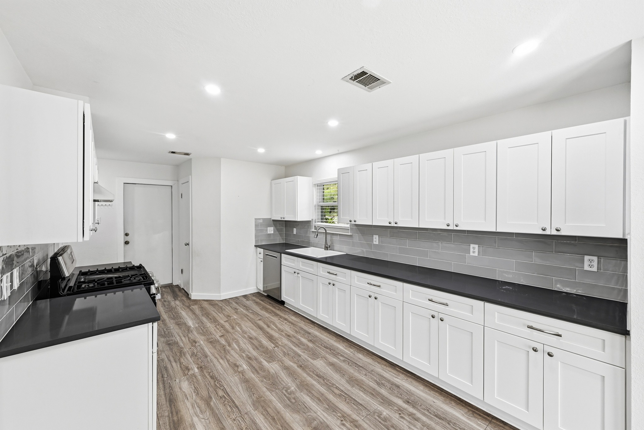 5812 Kayview Drive Austin, TX 78749 - Photo 11 of 31 a kitchen with granite countertop white cabinets and black appliances