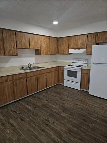 a kitchen with a sink cabinets and wooden floor