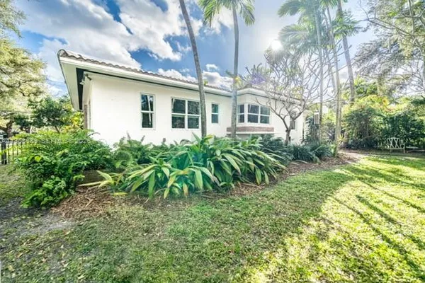 a view of a house with backyard and sitting area