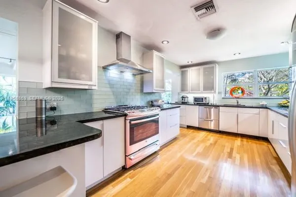 a kitchen with stainless steel appliances granite countertop a sink and a stove top oven