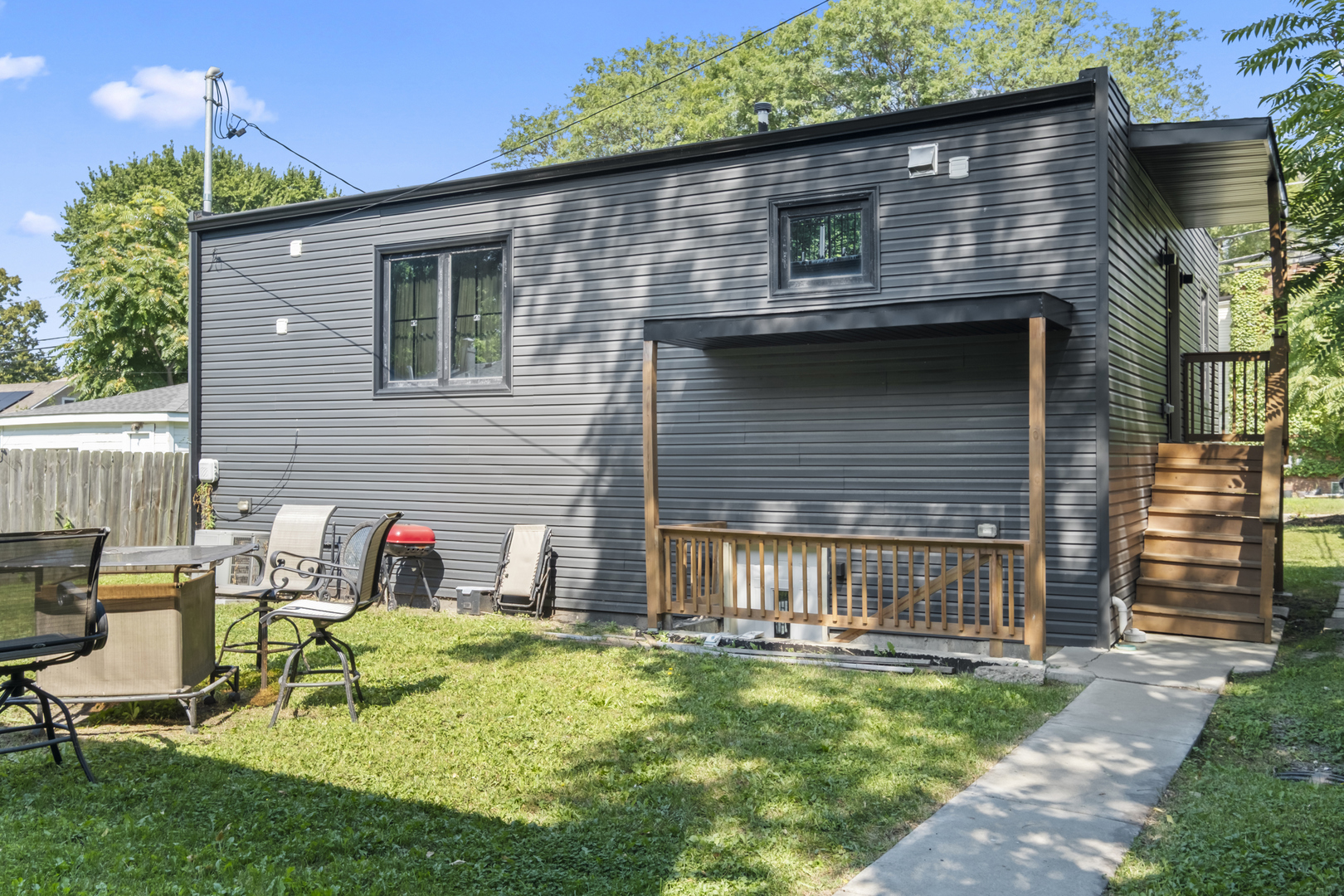 a backyard of a house with table and chairs