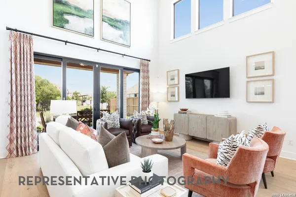 a living room with furniture a flat screen tv and a floor to ceiling window
