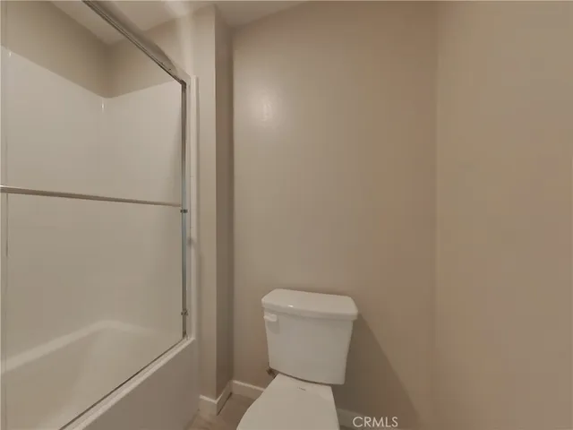 a white toilet sitting next to a bath tub