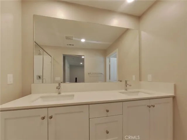 a bathroom with double sink and a mirror