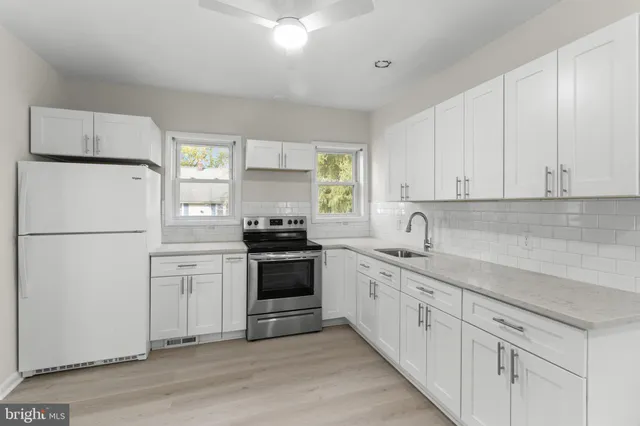 a kitchen with a refrigerator stove and white cabinets