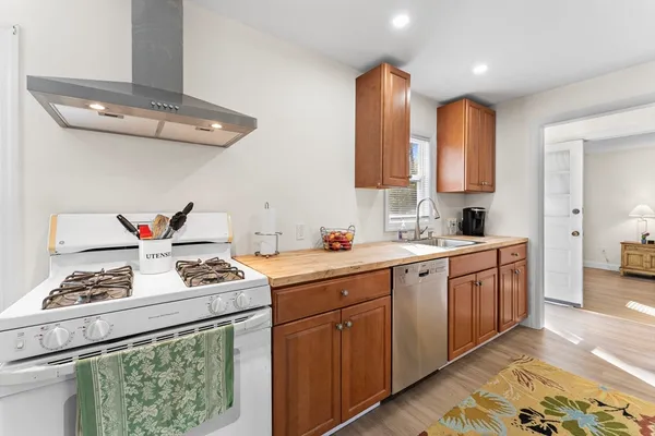 a kitchen with stainless steel appliances granite countertop a refrigerator stove top oven and cabinets