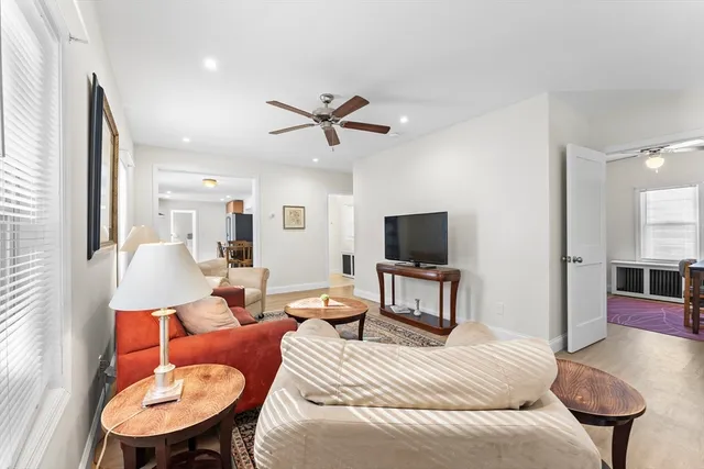 a living room with furniture a flat screen tv and kitchen view