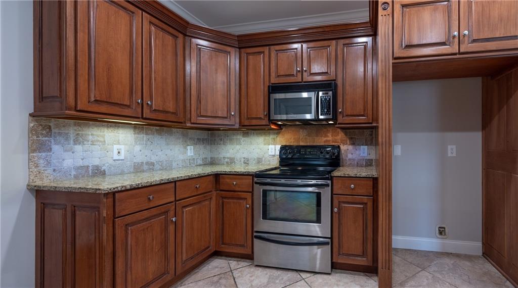 122 Caverns Way Northeast Calhoun, GA 30701 - Photo 17 of 56 a kitchen with granite countertop wooden cabinets and stainless steel appliances