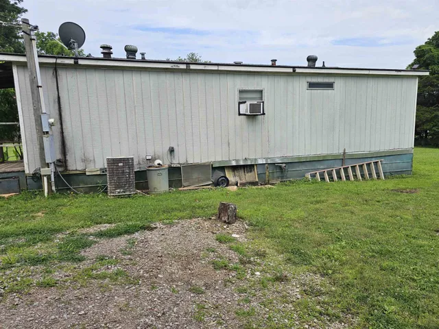 a backyard of a house with lawn chairs and wooden fence